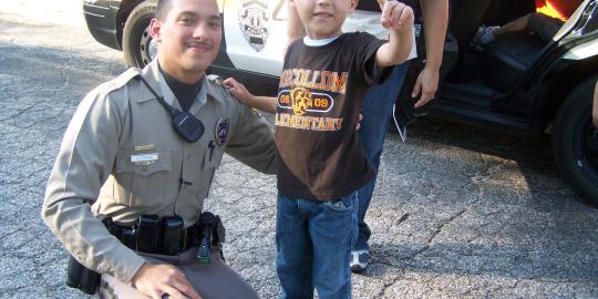 Police Officer stands with child