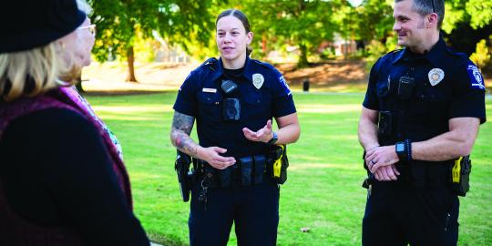 two officers talking to people in the park