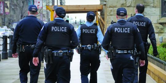 group of police officers walking down the street together