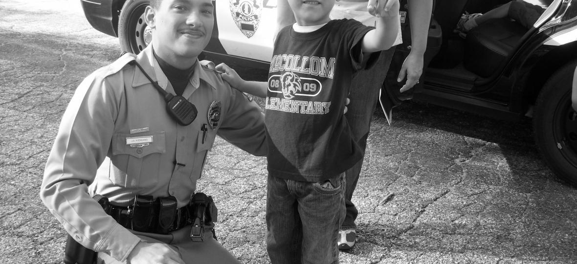 Police Officer stands with child