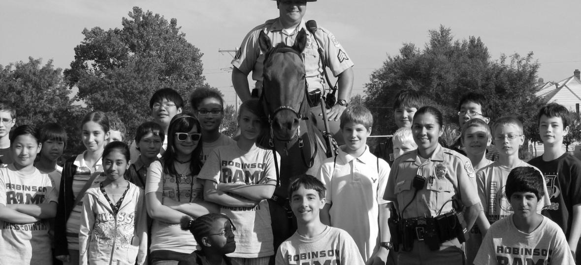 Officer on horseback smiling with children