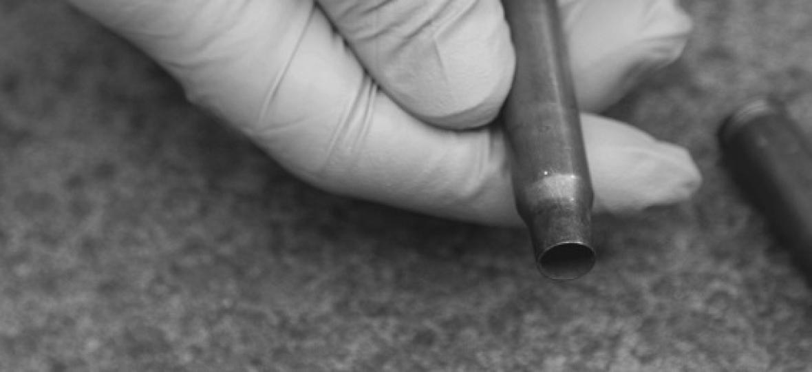 image of gloved hand holding a bullet casing
